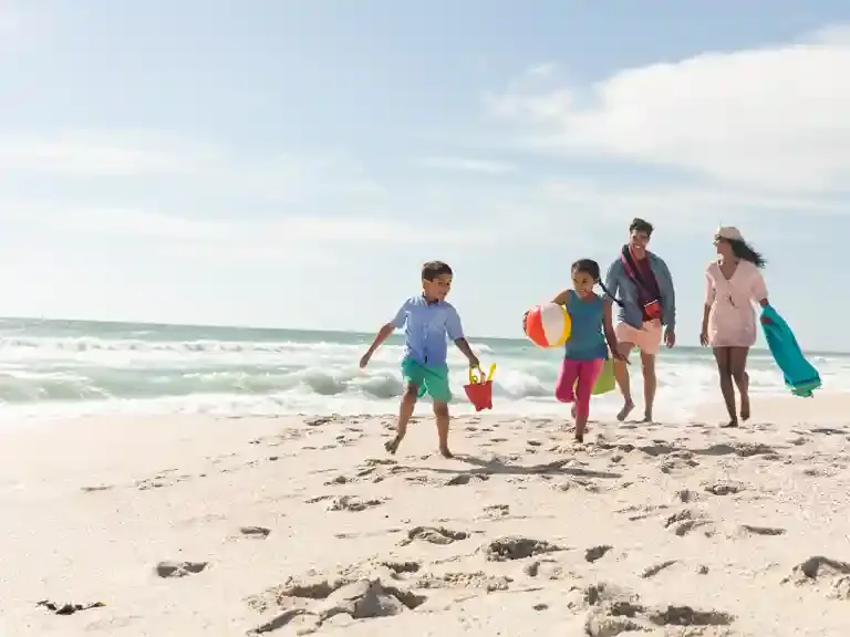Family enjoying a Zanzibar beach with kids playing in shallow waters and tropical scenery