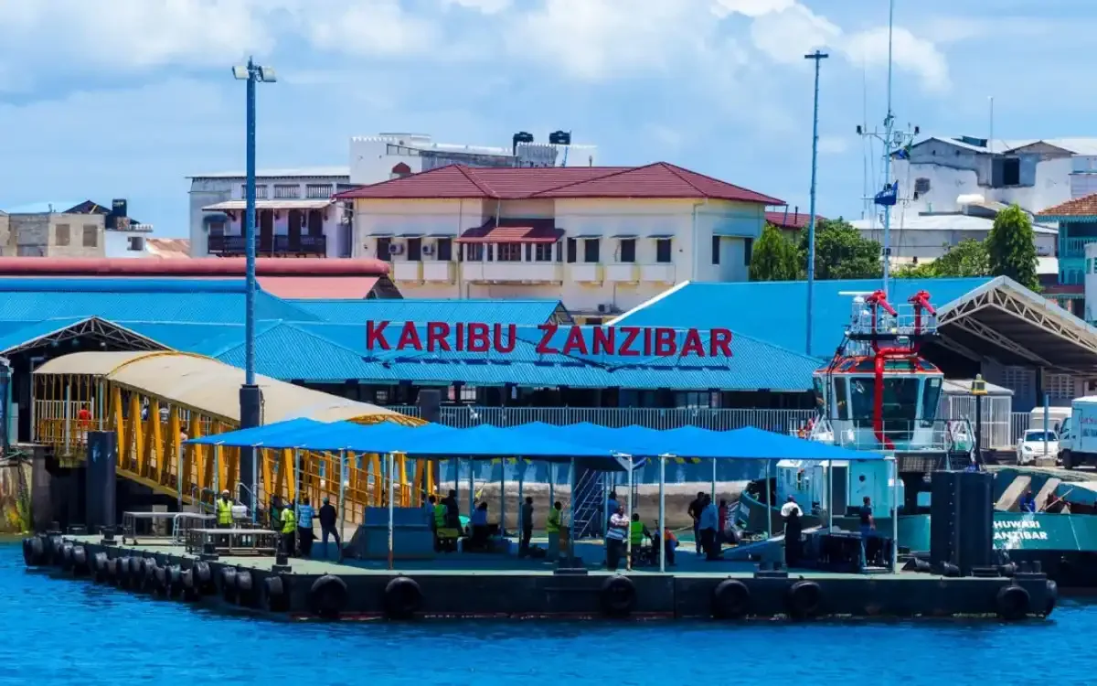Vibrant Zanzibar street scene with dala dala, taxis, and scooters, showcasing transport options